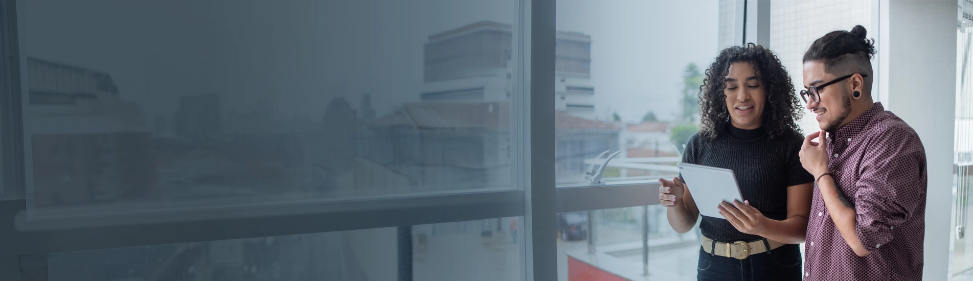 A man and a woman chatting while reading a tablet